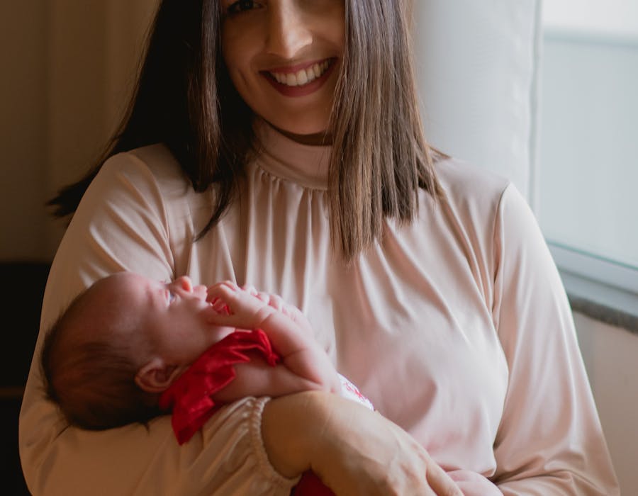 Mother holding newborn by window